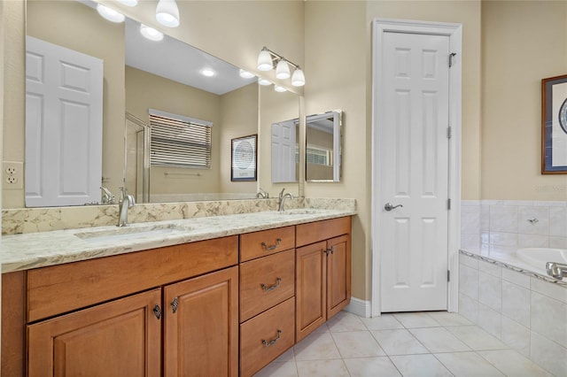 bathroom with vanity, tiled tub, and tile patterned floors