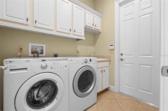 washroom with sink, cabinets, washing machine and clothes dryer, and light tile patterned flooring