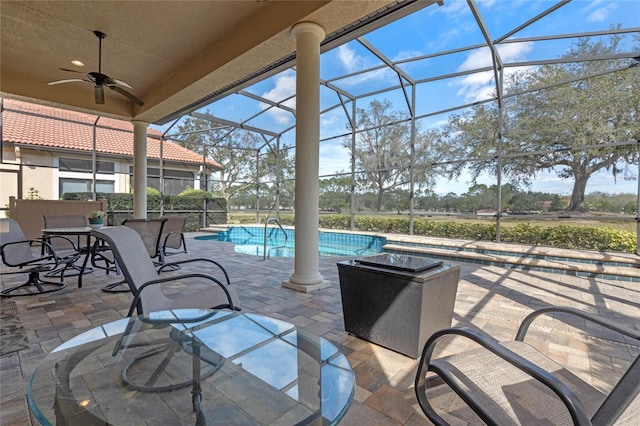 view of patio / terrace featuring ceiling fan and glass enclosure