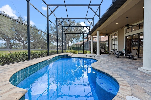 view of swimming pool featuring a patio area, ceiling fan, and glass enclosure