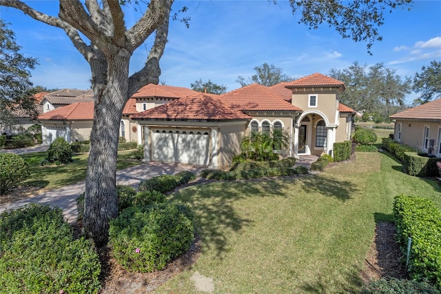 mediterranean / spanish-style home featuring a garage and a front yard