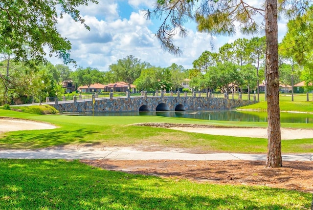 surrounding community featuring a lawn and a water view