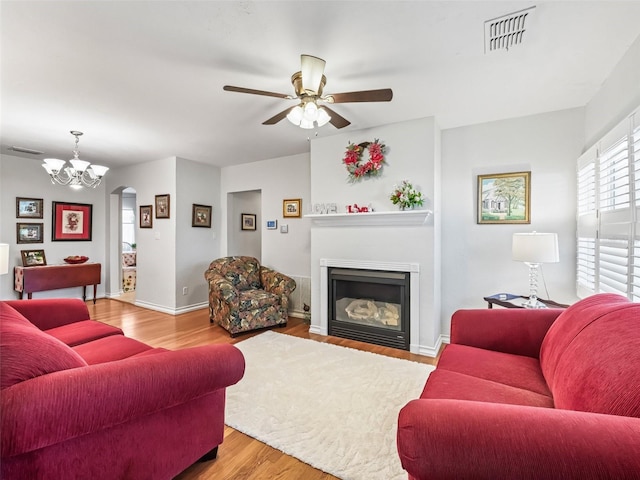 living room with light hardwood / wood-style flooring and ceiling fan with notable chandelier