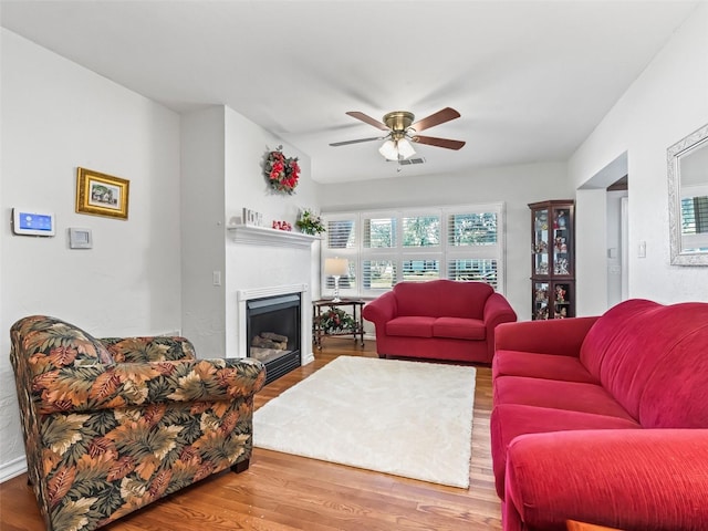 living room featuring ceiling fan and hardwood / wood-style flooring