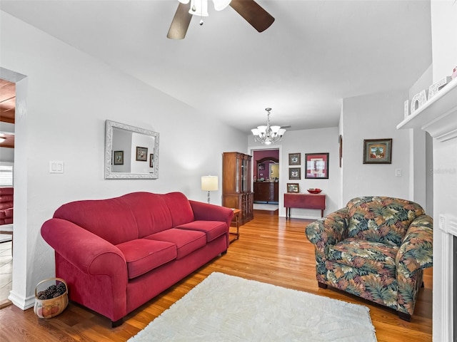 living room featuring ceiling fan with notable chandelier and wood-type flooring