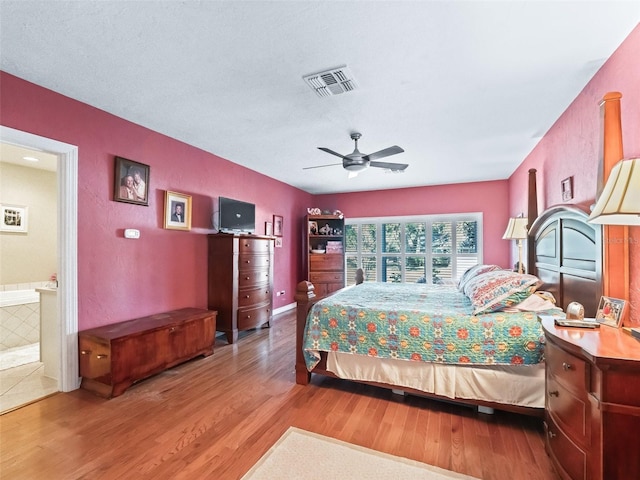 bedroom with hardwood / wood-style flooring, ensuite bath, and ceiling fan