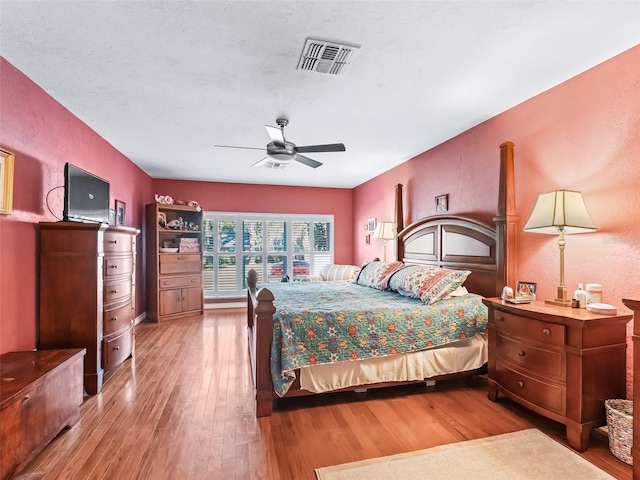 bedroom featuring hardwood / wood-style flooring, ceiling fan, and a textured ceiling