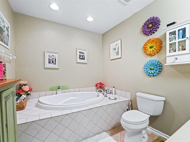 bathroom featuring toilet, vanity, tile patterned floors, and tiled tub