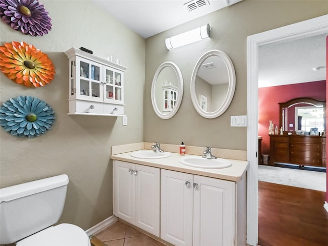 bathroom featuring toilet, vanity, and tile patterned floors