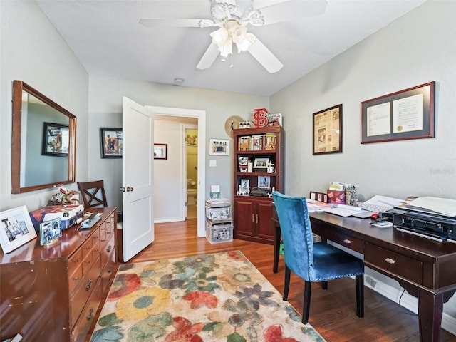 office with light wood-type flooring and ceiling fan