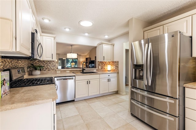 kitchen featuring pendant lighting, backsplash, sink, light tile patterned floors, and stainless steel appliances