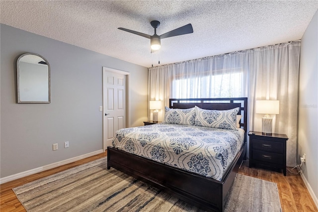 bedroom with wood-type flooring, a textured ceiling, and ceiling fan