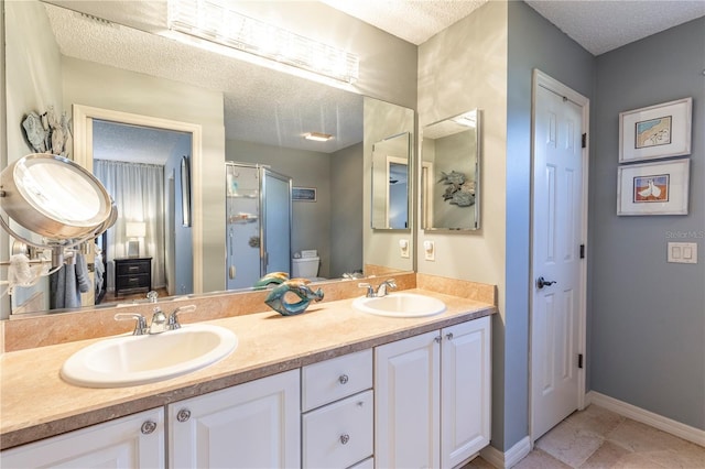 bathroom with walk in shower, vanity, a textured ceiling, and toilet