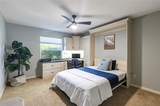 bedroom featuring light carpet, a textured ceiling, and ceiling fan