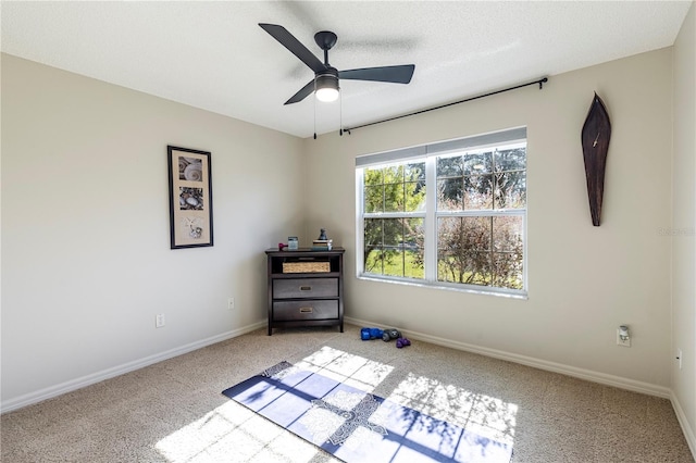 carpeted empty room featuring ceiling fan and a textured ceiling