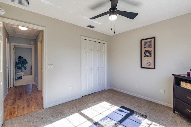 bedroom featuring ceiling fan, light carpet, and a closet