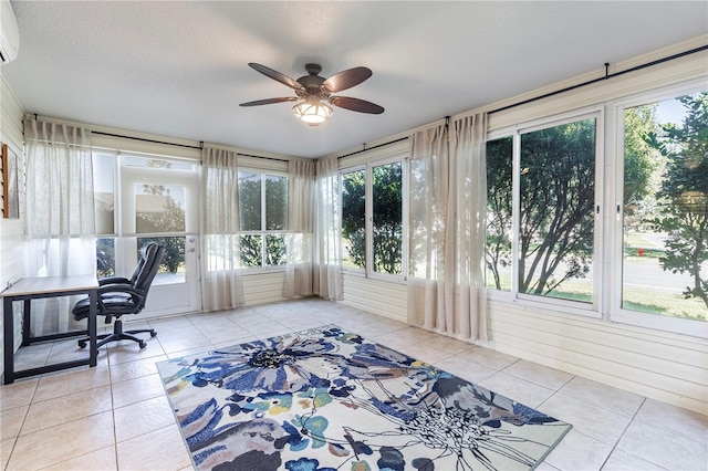 office area featuring a wall mounted AC, ceiling fan, light tile patterned flooring, and a healthy amount of sunlight