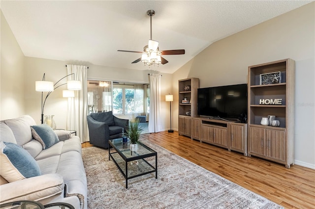 living room featuring ceiling fan, vaulted ceiling, and light hardwood / wood-style floors