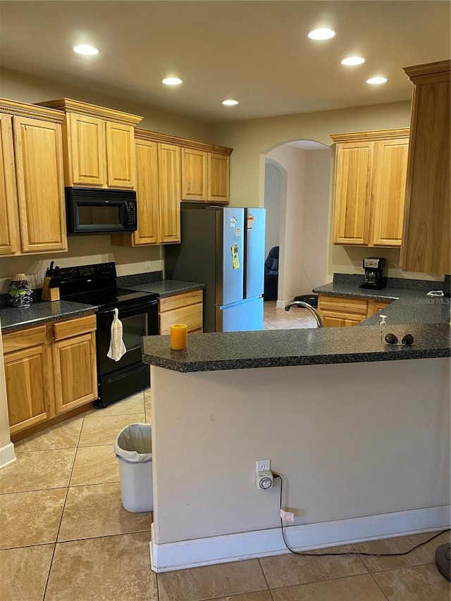 kitchen featuring dark stone counters, kitchen peninsula, light tile patterned floors, and black appliances