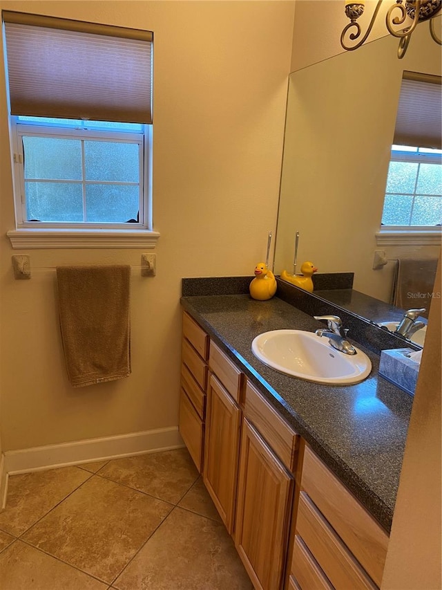 bathroom with tile patterned flooring, vanity, and an inviting chandelier