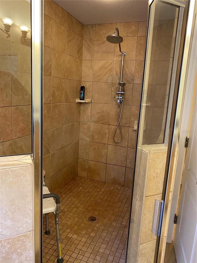 bathroom featuring a shower with door and a textured ceiling