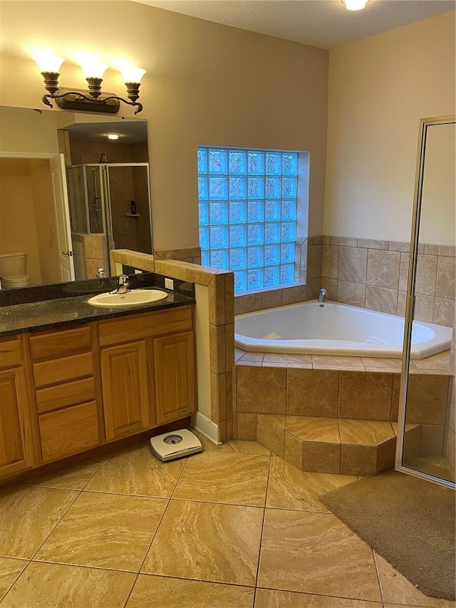 full bathroom featuring plus walk in shower, vanity, tile patterned floors, and toilet