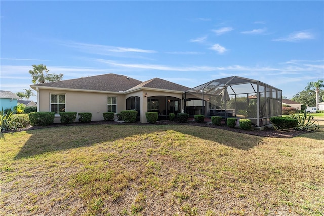 back of house featuring a lawn, a lanai, and stucco siding