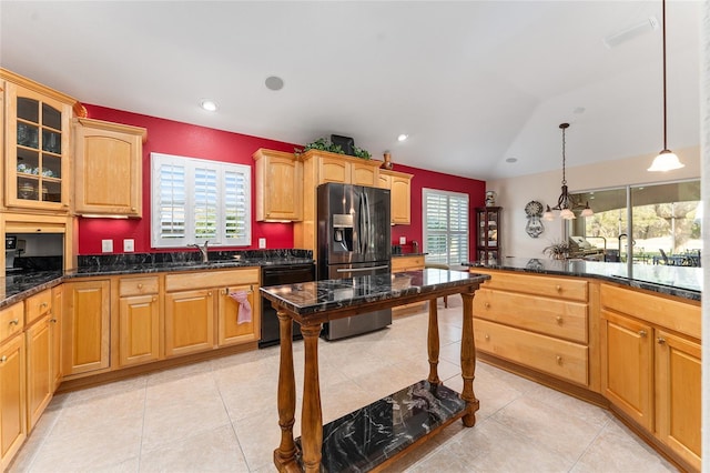 kitchen featuring vaulted ceiling, pendant lighting, dark stone countertops, dishwasher, and stainless steel fridge with ice dispenser