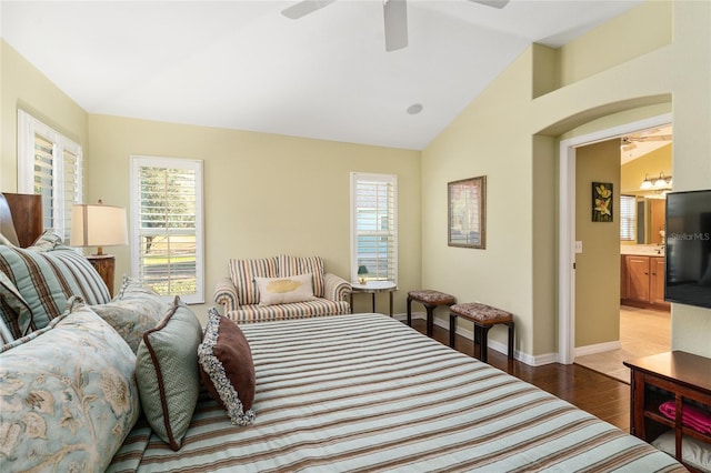 bedroom with lofted ceiling, ensuite bathroom, light hardwood / wood-style flooring, ceiling fan, and multiple windows