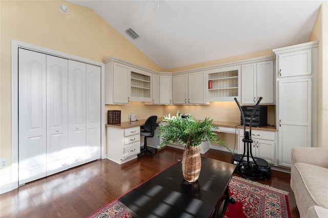 office area featuring dark hardwood / wood-style flooring, built in desk, vaulted ceiling, and ceiling fan