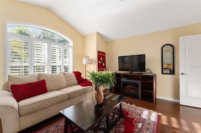 living room with plenty of natural light, dark hardwood / wood-style floors, and lofted ceiling