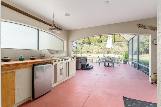 view of patio / terrace with area for grilling, glass enclosure, and an outdoor kitchen