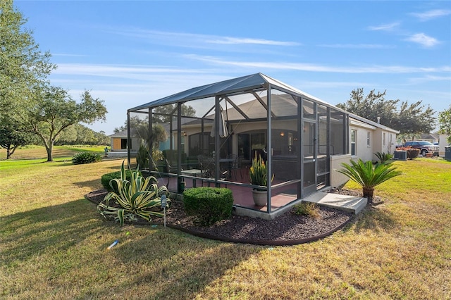 back of property featuring a lanai and a lawn