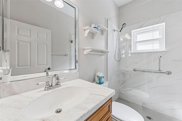 full bathroom featuring a marble finish shower, toilet, and vanity