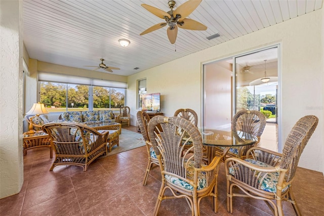 sunroom / solarium featuring a wealth of natural light, visible vents, and ceiling fan