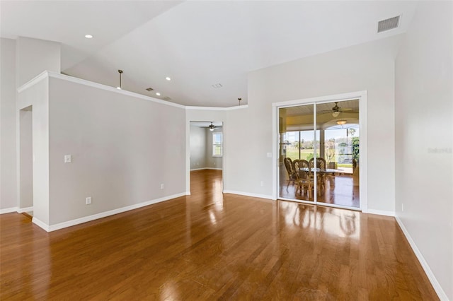 empty room with visible vents, baseboards, wood finished floors, and a ceiling fan