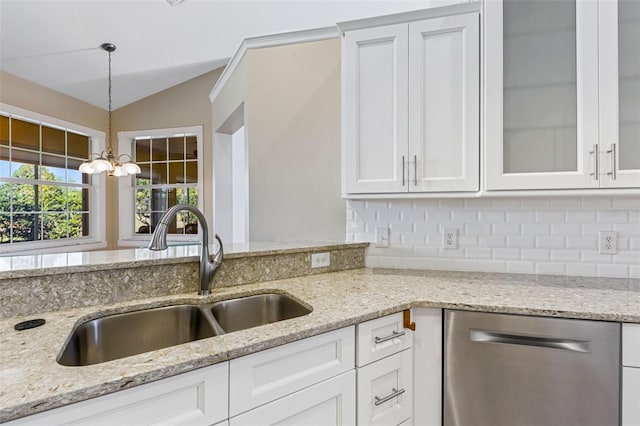 kitchen featuring white cabinetry, lofted ceiling, a sink, hanging light fixtures, and dishwasher