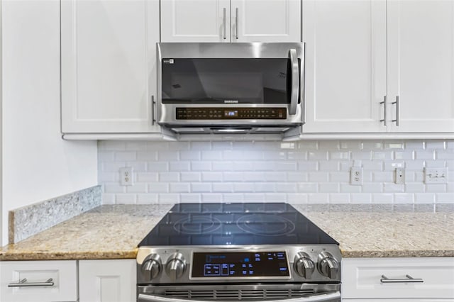 kitchen featuring backsplash, appliances with stainless steel finishes, and white cabinets