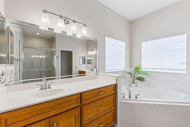 full bathroom with a bath, a shower stall, and vanity