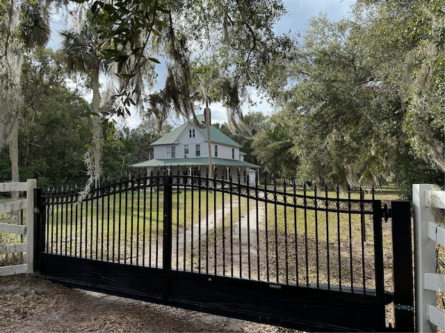 view of gate with a yard