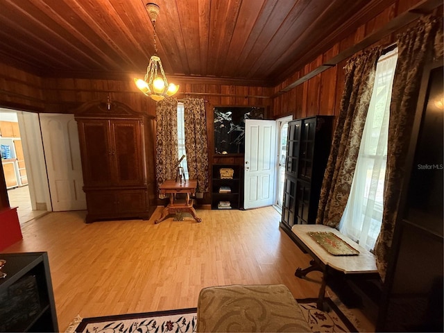 interior space featuring an inviting chandelier, light hardwood / wood-style flooring, wood walls, and wood ceiling