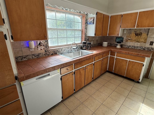 kitchen featuring tasteful backsplash, tile counters, white dishwasher, and sink