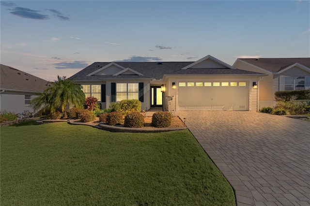 ranch-style house featuring a yard and a garage