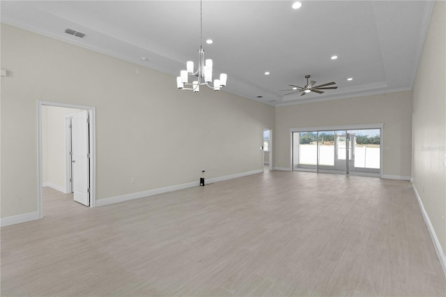 empty room featuring ceiling fan with notable chandelier, ornamental molding, a tray ceiling, and light hardwood / wood-style flooring