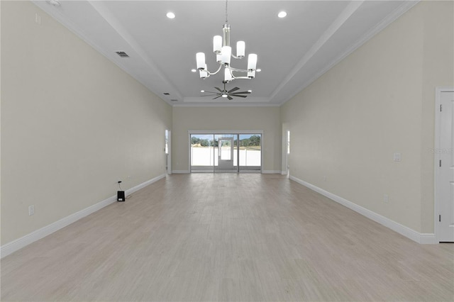 spare room featuring ceiling fan with notable chandelier, light wood-type flooring, a tray ceiling, and ornamental molding