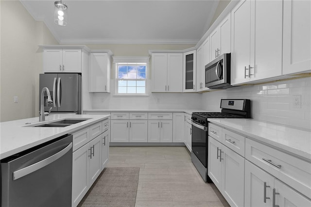 kitchen featuring backsplash, sink, light stone countertops, white cabinetry, and stainless steel appliances