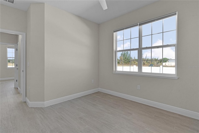 empty room with ceiling fan and light hardwood / wood-style floors