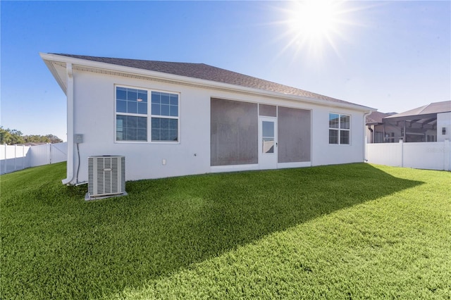 back of property with a yard and central air condition unit