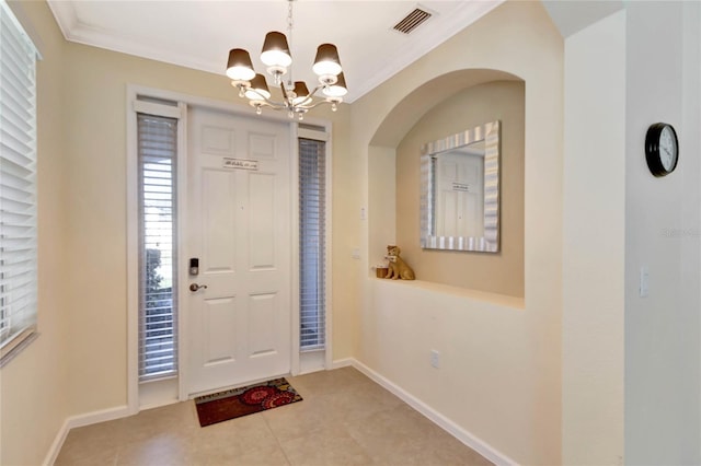 entrance foyer featuring a chandelier, light tile patterned floors, and ornamental molding