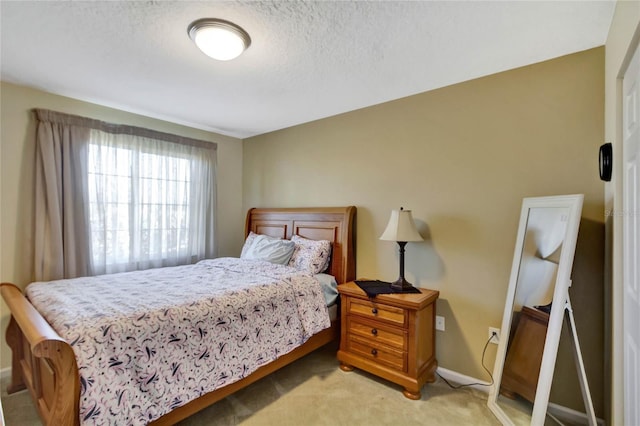 bedroom featuring a textured ceiling and light carpet